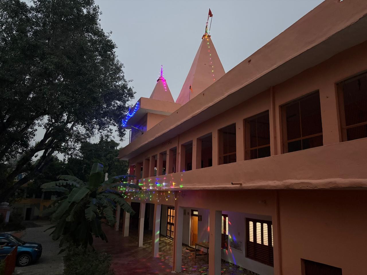 Evening at the Ashram — the twin shikharas and verandah lit with festive lights during Deepotsav — आश्रम की संध्या — दीपोत्सव पर रोशनी से सजे दोनों शिखर एवं बरामदा